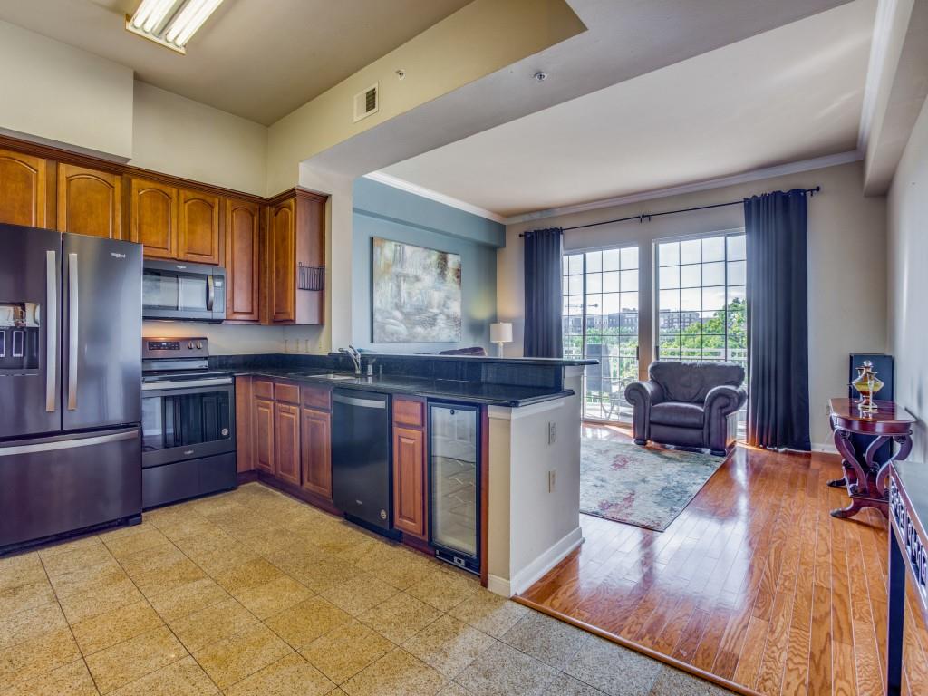 a kitchen with granite countertop a stove refrigerator and wooden cabinets