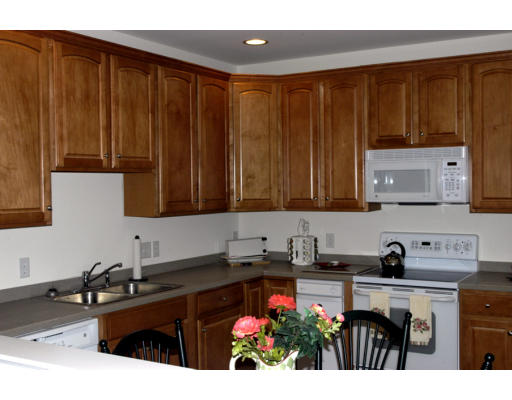 170 Haverhill Street, Unit 138 Andover, MA 01810 - Photo 3 of 16 a kitchen with wooden cabinets a sink and a stove