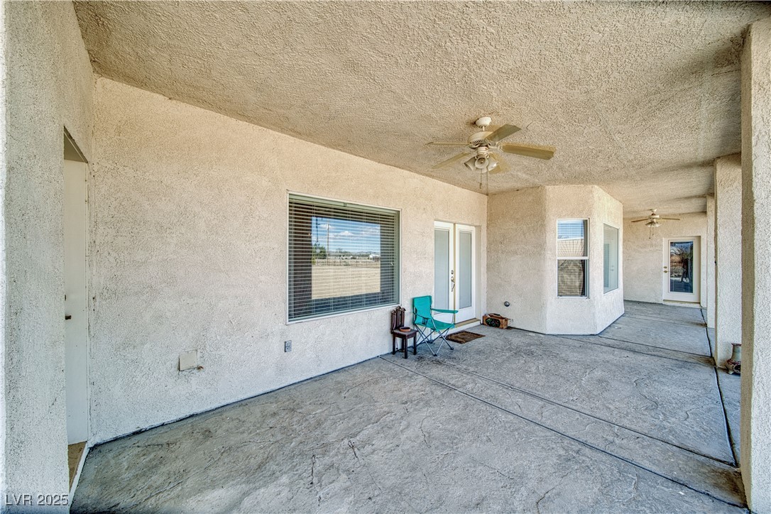 660 Indian Road Pahrump, NV 89048 - Photo 46 of 54 View of massive 42 X 13 covered patio, textured concrete flooring, door access to family room and primary bedroom, & 2 outdoor rated ceiling fans.