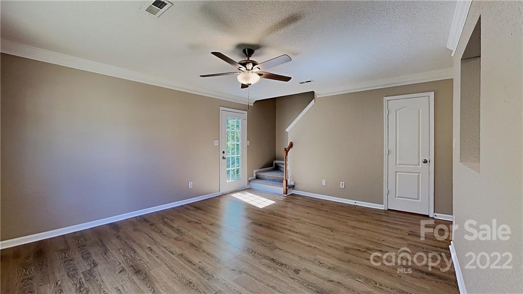 701 Raindrops Road Gastonia, NC 28054 - Photo 12 of 14 an empty room with wooden floor ceiling fan and windows