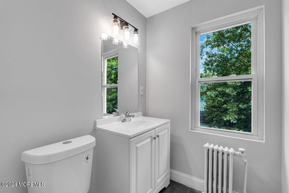 57 Jackson Street Freehold, NJ 07728 - Photo 17 of 48 a bathroom with a sink a toilet and a window