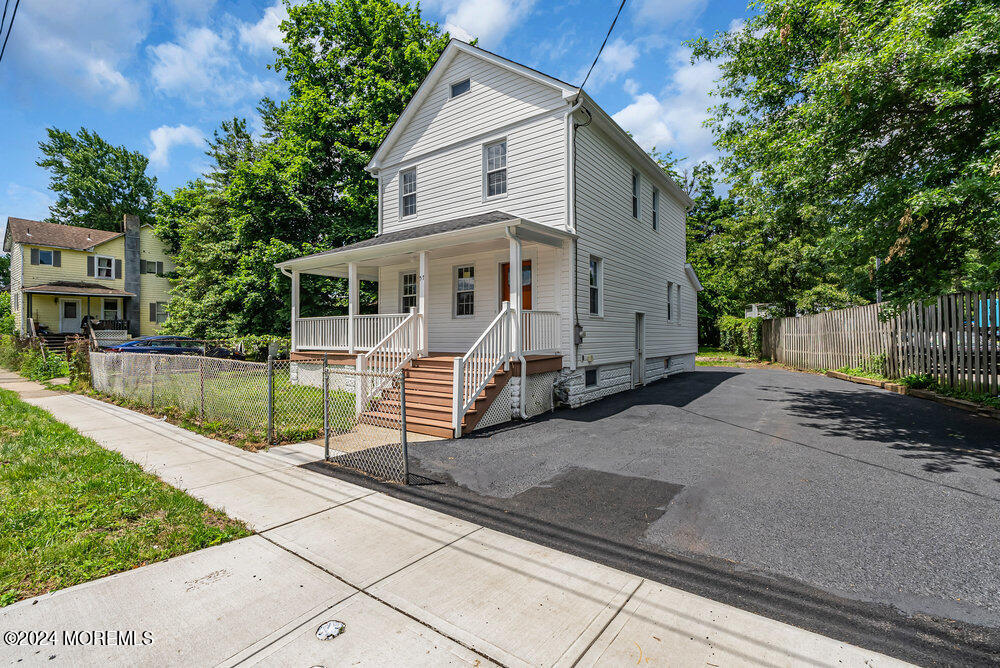 57 Jackson Street Freehold, NJ 07728 - Photo 2 of 48 a view of a white house with a small yard and large tree and wooden fence