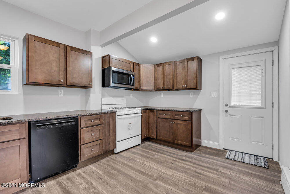 57 Jackson Street Freehold, NJ 07728 - Photo 8 of 48 a kitchen with stainless steel appliances granite countertop wooden cabinets a stove top oven a sink and dishwasher