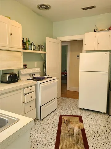 a kitchen with a refrigerator and a stove