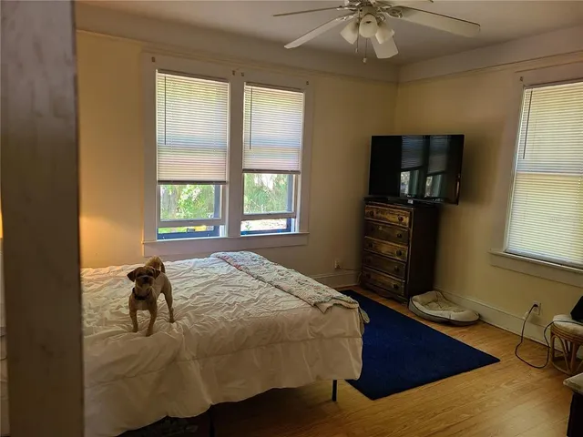 a bedroom with a bed and wooden floor