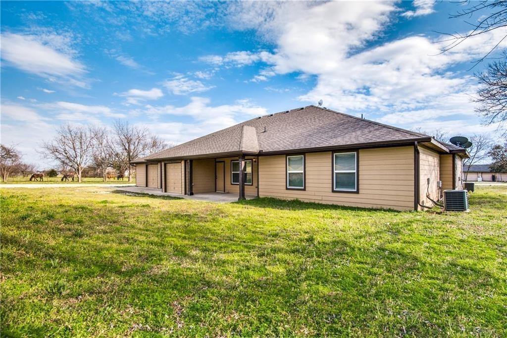 6452 Gregg Road Krum, TX 76249 - Photo 1 of 10 Rear view of property featuring a patio area, a yard, a garage, and a shingled roof