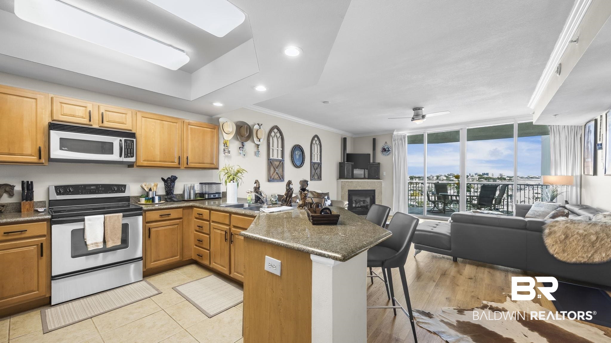 27800 Canal Road, Unit 313 Orange Beach, AL 36561 - Photo 23 of 23 Kitchen with stainless steel appliances, a peninsula, open floor plan, a kitchen bar, and crown molding