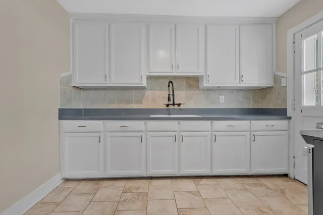 a kitchen with granite countertop a sink stove and cabinets