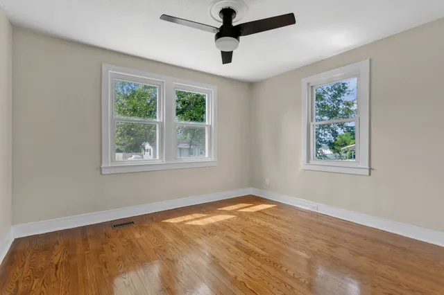 a view of an empty room with wooden floor