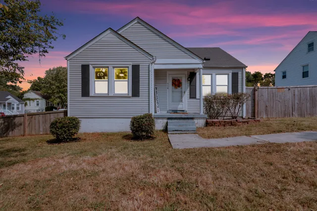 a view of a house with backyard and a tree