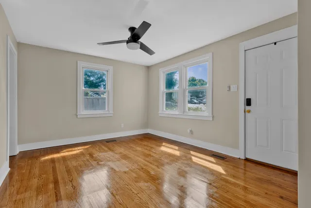 a view of an empty room with wooden floor