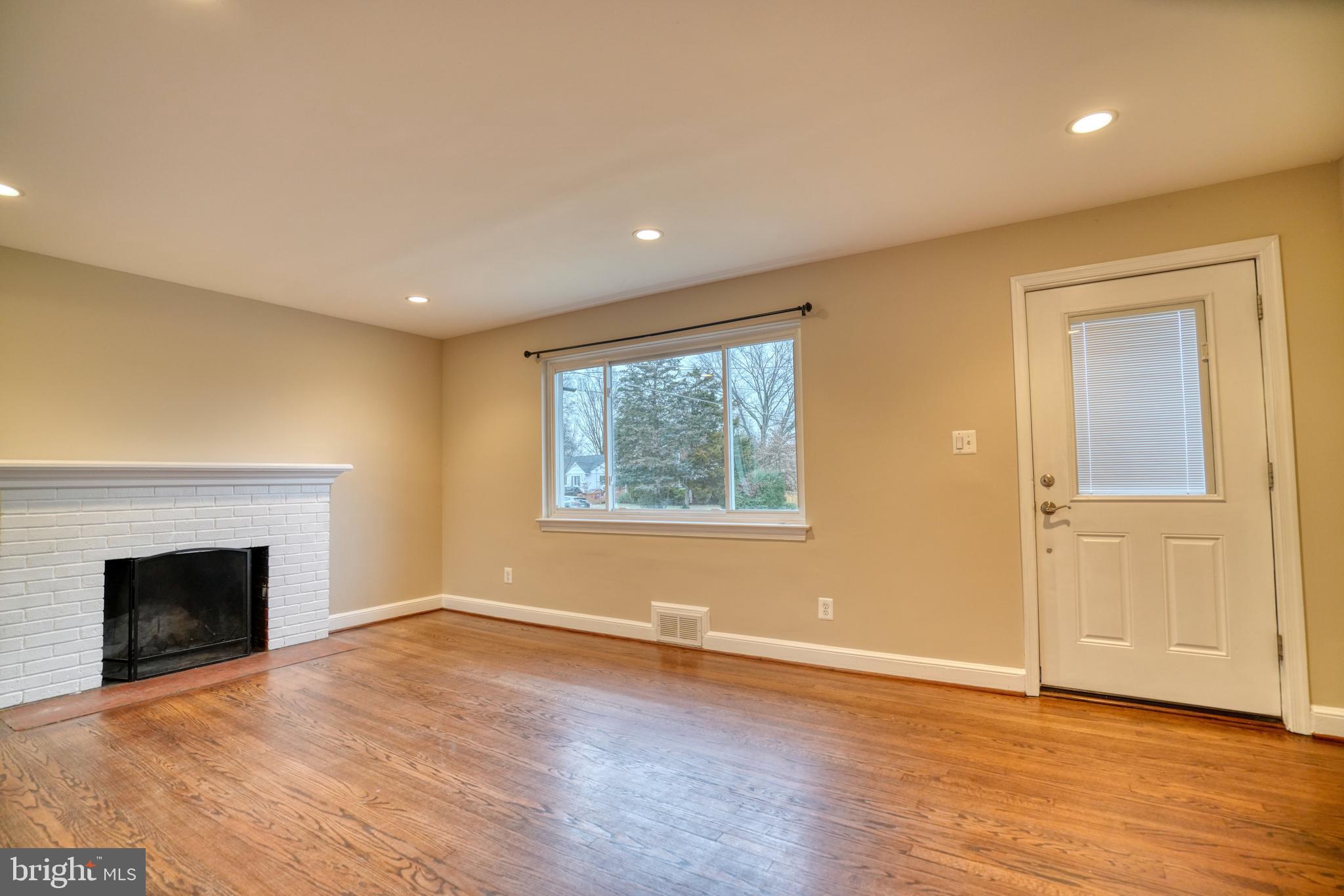 6000 Grayson Street Springfield, VA 22150 - Photo 2 of 37 an empty room with wooden floor and fireplace