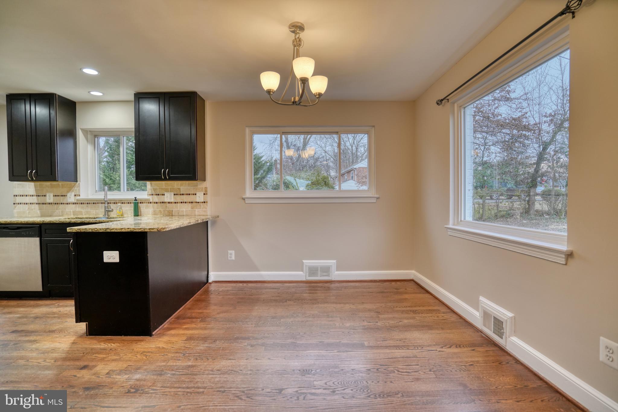 6000 Grayson Street Springfield, VA 22150 - Photo 6 of 37 a view of kitchen with kitchen island a sink wooden floor and a large window