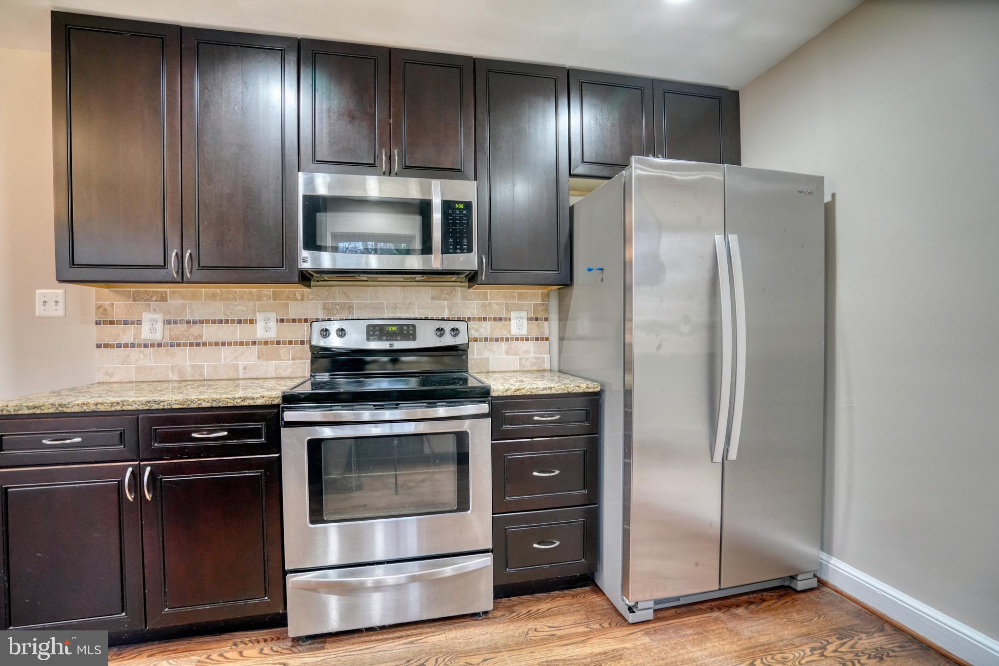 6000 Grayson Street Springfield, VA 22150 - Photo 10 of 37 a kitchen with granite countertop wooden cabinets and stainless steel appliances