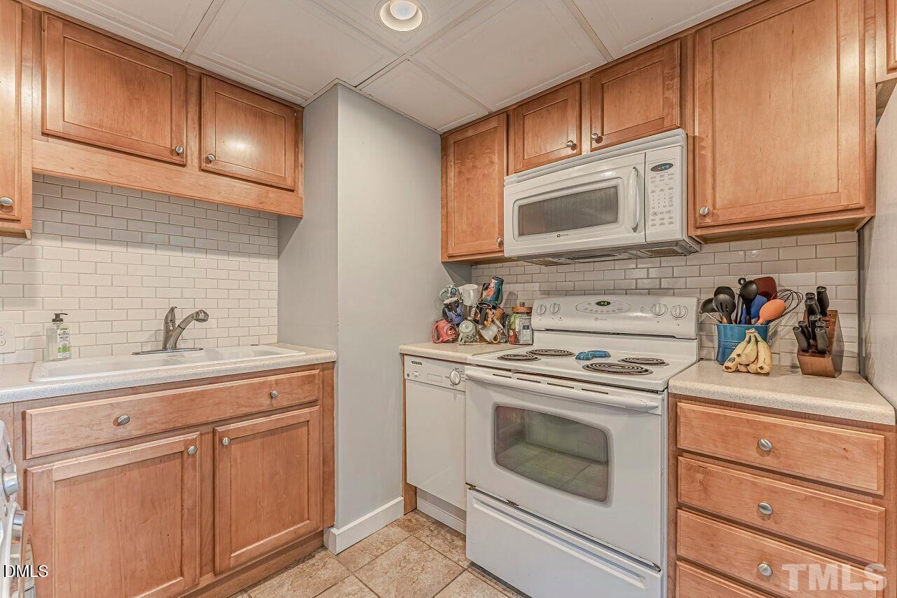 1037 St Marys Street, Unit 1037 Raleigh, NC 27605 - Photo 20 of 36 a kitchen with cabinets stainless steel appliances a sink and cabinets