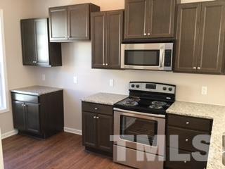 844 Horton Road, Unit 51 Durham, NC 27704 - Photo 5 of 13 a kitchen with stainless steel appliances granite countertop a stove microwave and sink