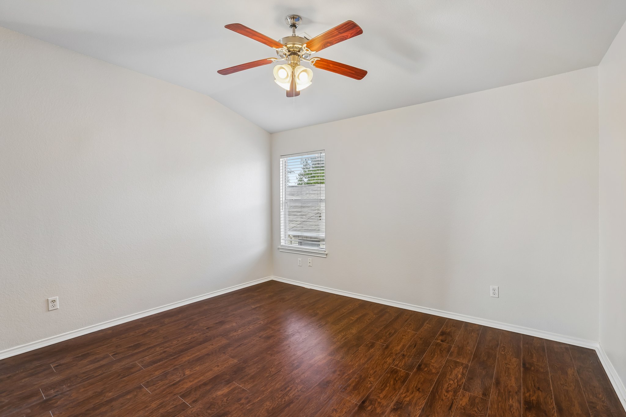 1721 Long Rifle Drive Austin, TX 78754 - Photo 22 of 38 Laminated flooring and a ceiling fan with light fixtures create a cozy atmosphere in this adaptable space.