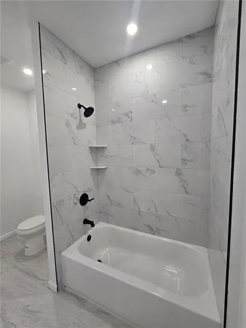 a bathroom with a bathtub and a toilet