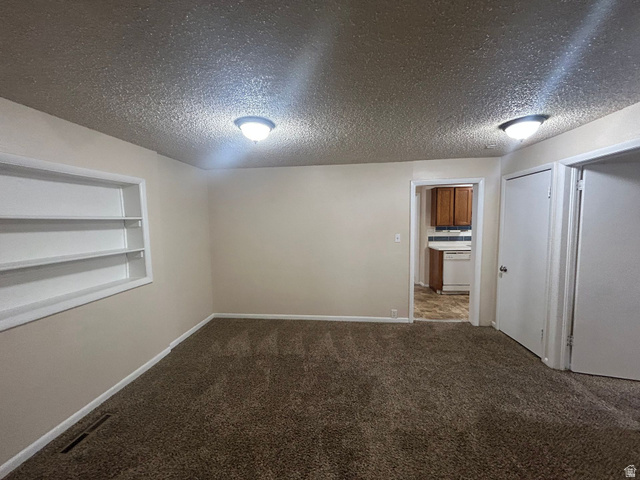 265 Rigdon Avenue, Unit 1 Salt Lake City, UT 84115 - Photo 5 of 15 Carpeted room with neutral wall paint and built-in shelving