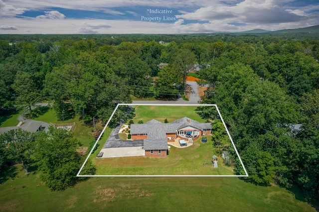 an aerial view of a house with a yard basket ball court and outdoor seating