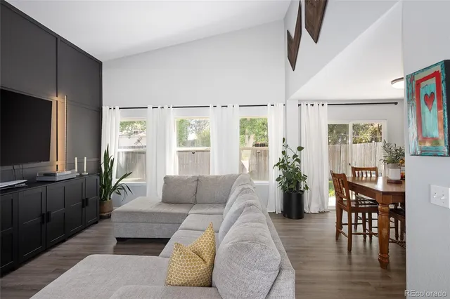 a living room with furniture a flat screen tv and wooden floor