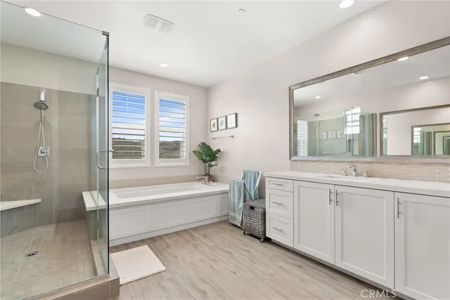 a bathroom with a tub sink shower and mirror