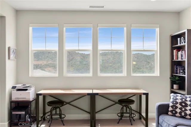 a view of a workspace with furniture and a window