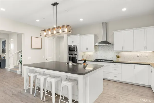 a kitchen with stainless steel appliances granite countertop a sink a stove and a refrigerator