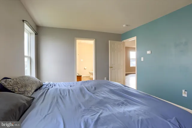 a spacious bedroom with a bed and a window