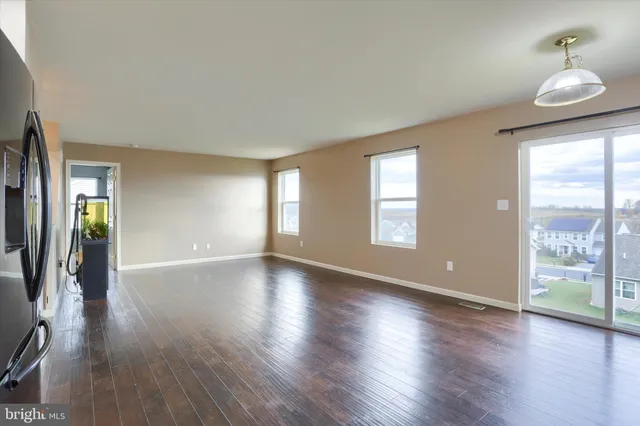 a view of a big room with wooden floor and a kitchen