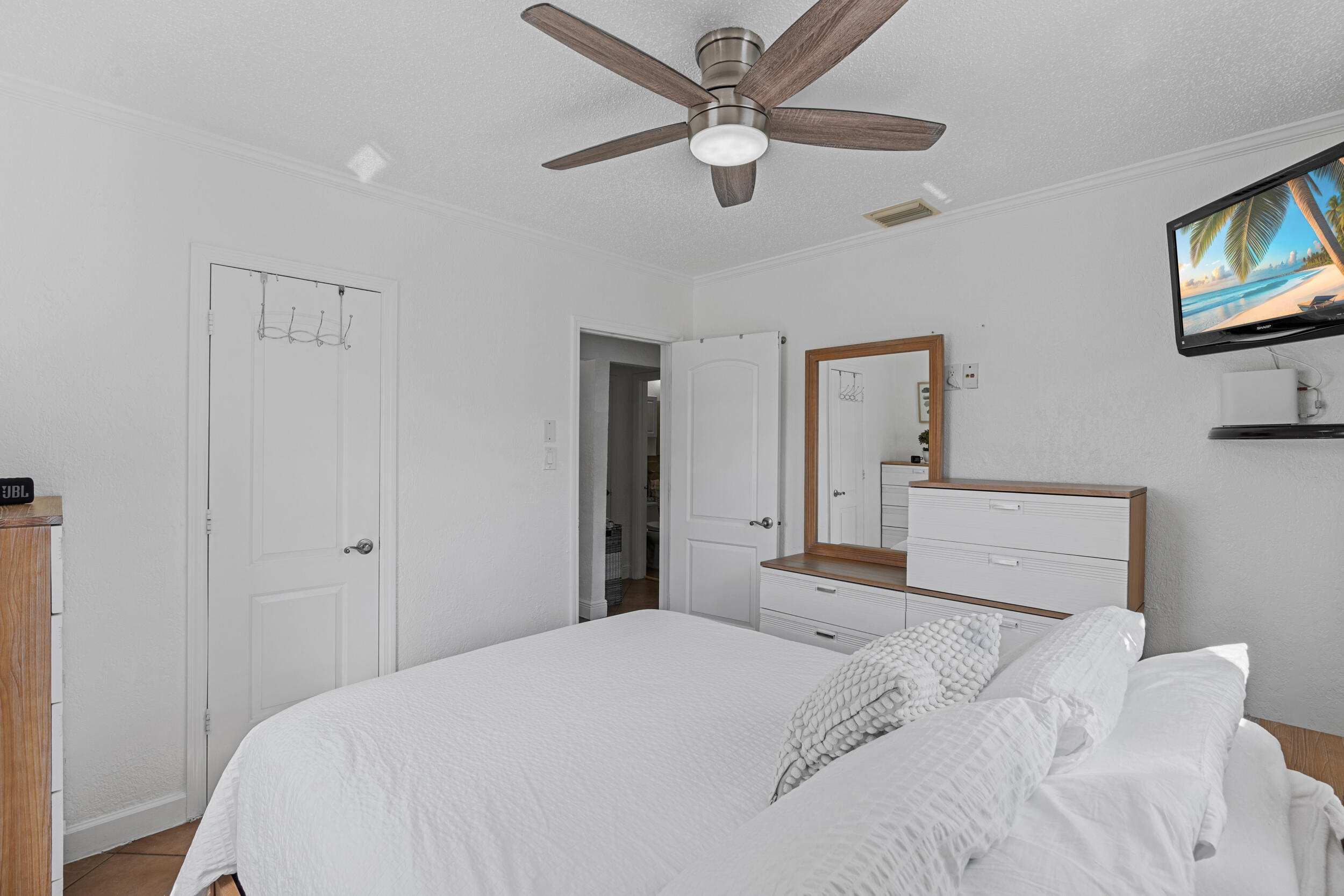 31 Miami Gardens Road West Park, FL 33023 - Photo 9 of 36 a bedroom with a large bed and a chandelier
