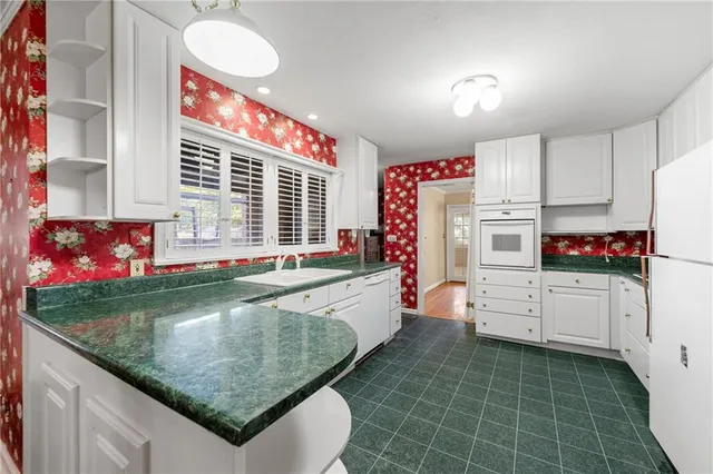 a kitchen with white cabinets and appliances