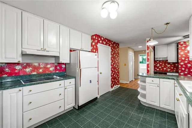 a kitchen with granite countertop white cabinets and window