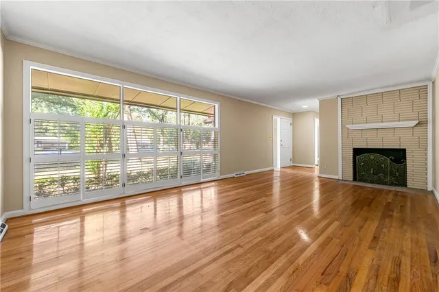 a view of empty room with wooden floor and fireplace