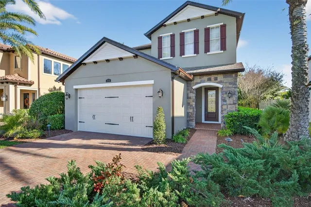 a view of a house with a small yard plants and large tree