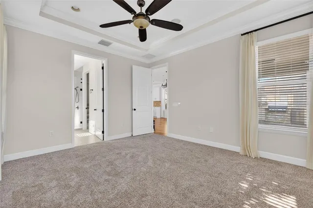 an empty room with windows and ceiling fan