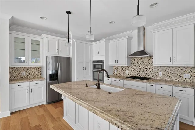 a kitchen with granite countertop a sink a counter top space cabinets and stainless steel appliances