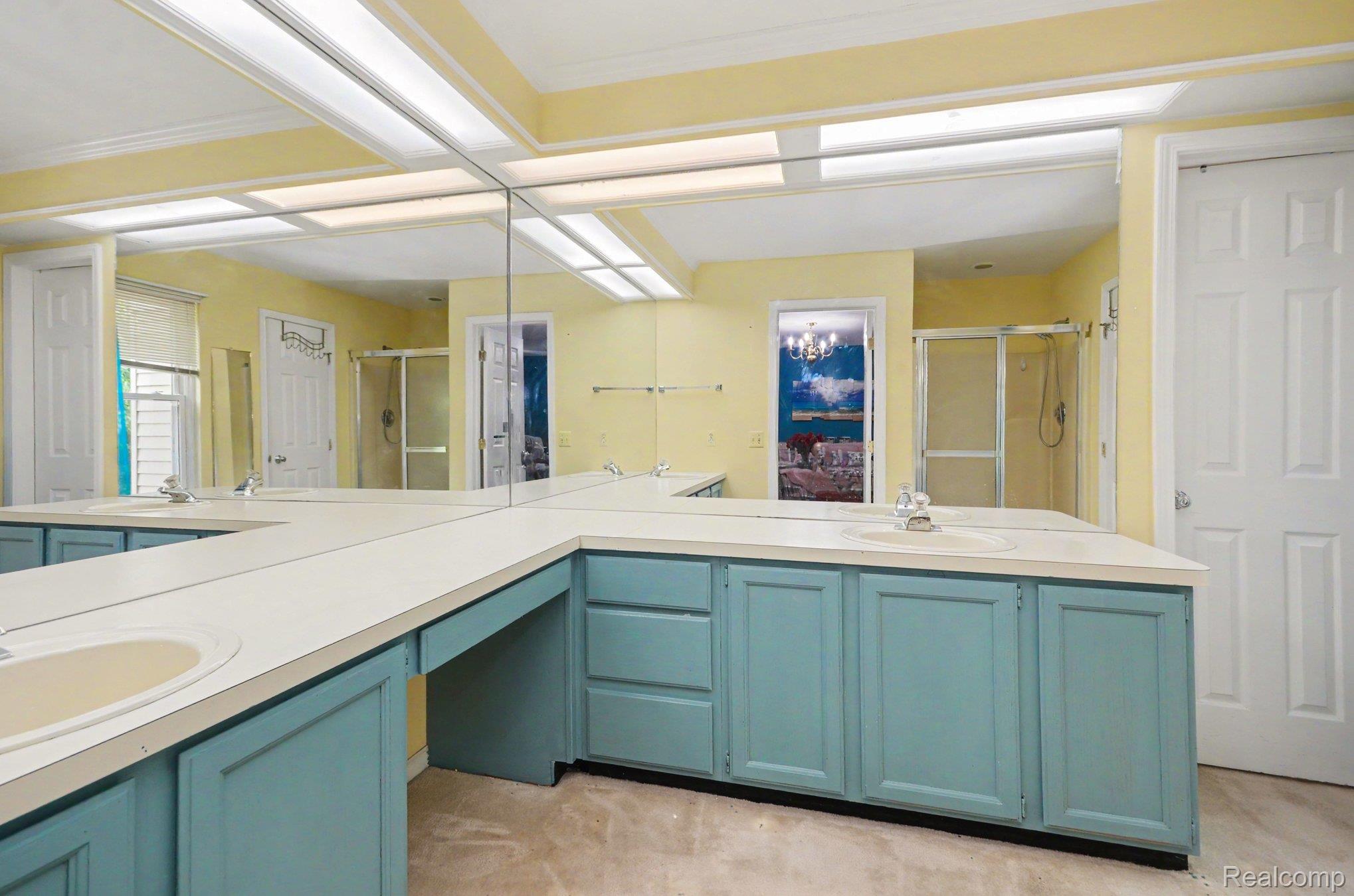 425 Thornridge Court Rochester, MI 48307 - Photo 19 of 35 Expansive vanity area featuring multiple sinks, ample counter space, built-in cabinetry, full-wall mirror, and overhead lighting
