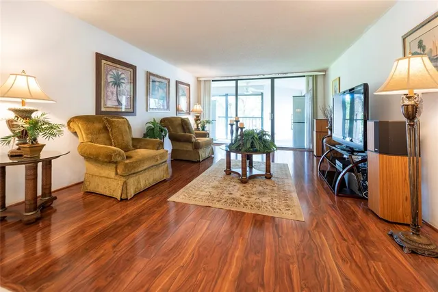 a living room with furniture hard wood floor and a flat screen tv