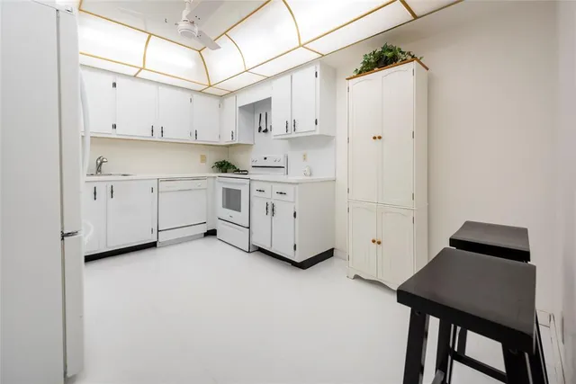 a kitchen with white cabinets and white appliances