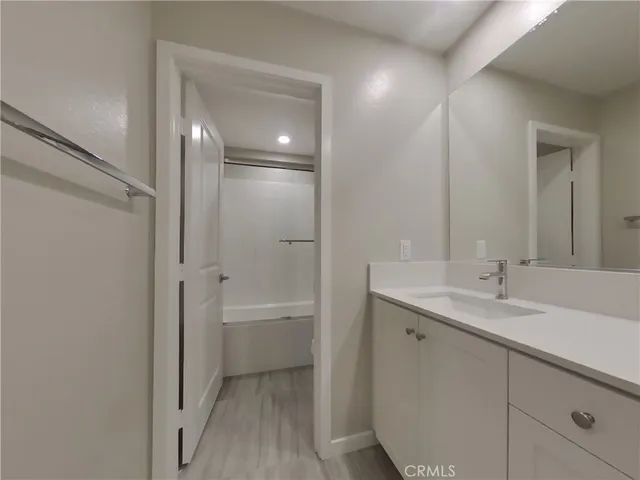 a bathroom with a granite countertop sink a mirror and a bathtub