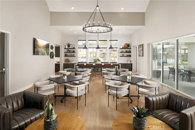 a living room with couches a fireplace and kitchen view with wooden floor