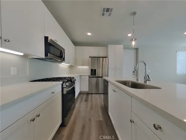 a kitchen with a sink stainless steel appliances and cabinets
