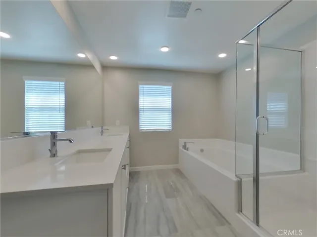 a bathroom with a tub sink and mirror