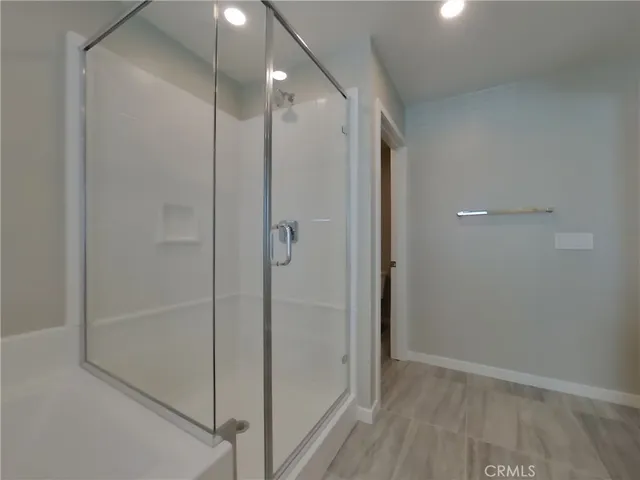 a bathroom with a shower and a glass door