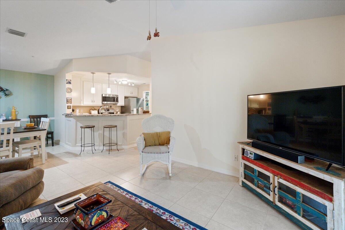 7667 North Wickham Road, Unit 916 Melbourne, FL 32940 - Photo 13 of 53 a living room with furniture and a flat screen tv