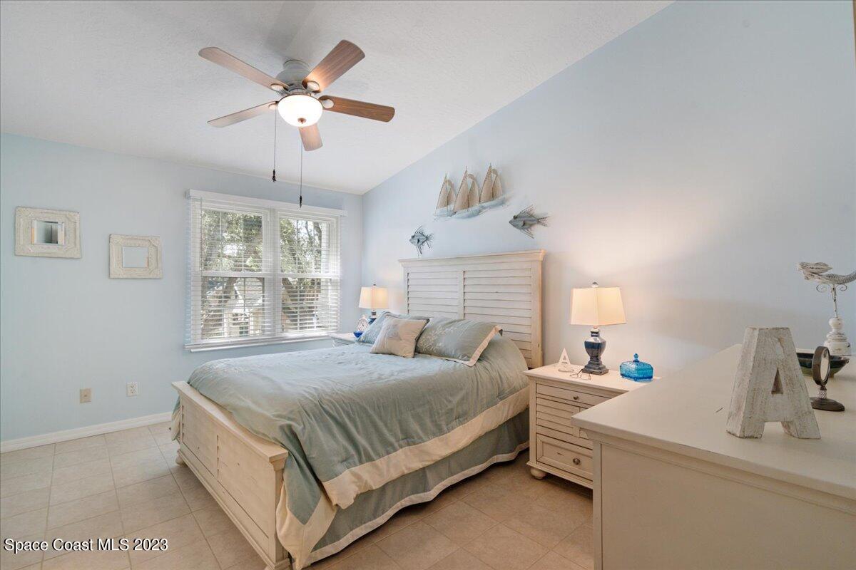 7667 North Wickham Road, Unit 916 Melbourne, FL 32940 - Photo 25 of 53 a bedroom with a large bed and a chandelier