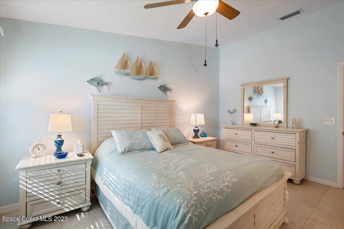 7667 North Wickham Road, Unit 916 Melbourne, FL 32940 - Photo 26 of 53 a bedroom with a bed and a chandelier