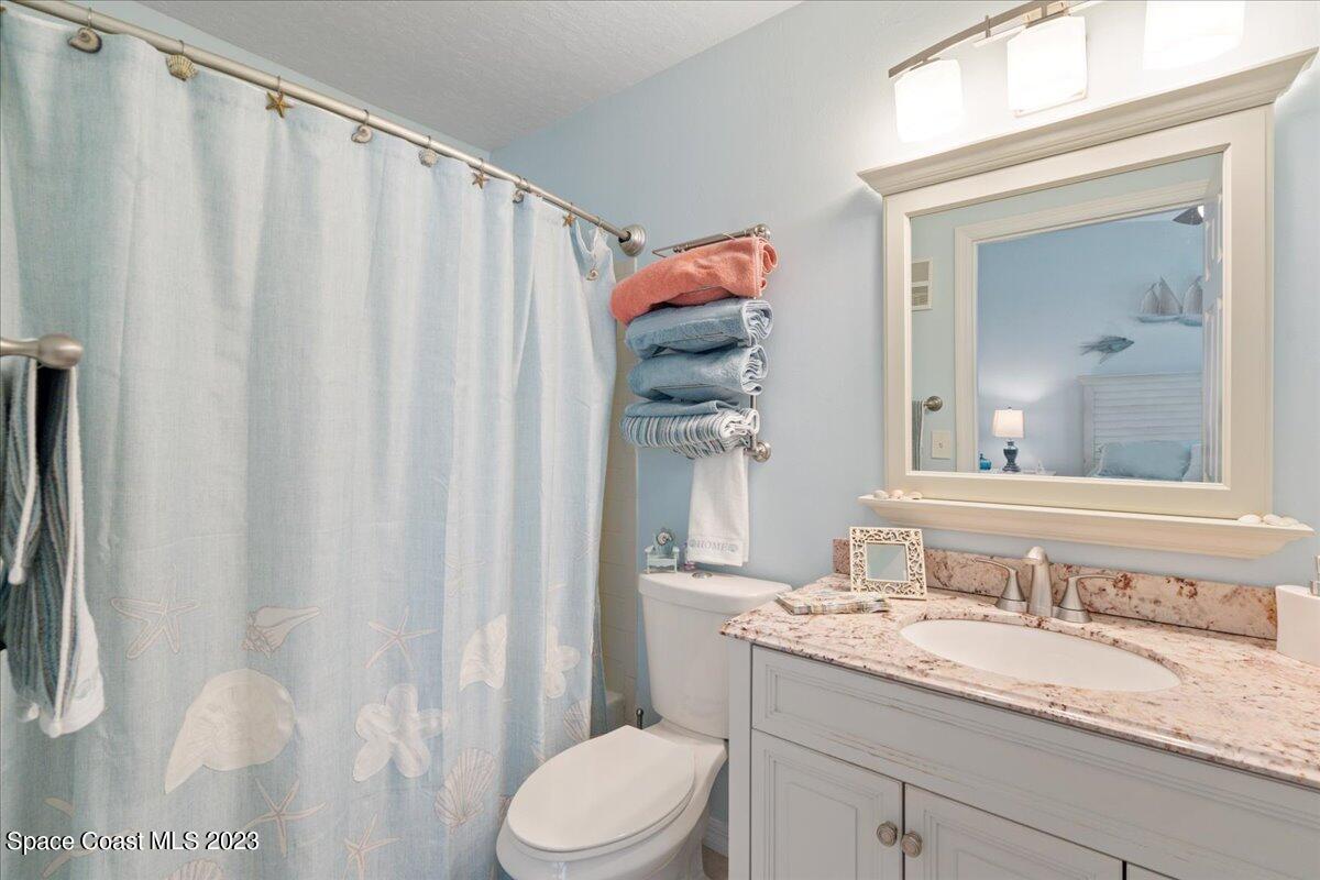 7667 North Wickham Road, Unit 916 Melbourne, FL 32940 - Photo 29 of 53 a bathroom with a granite countertop sink vanity mirror and toilet