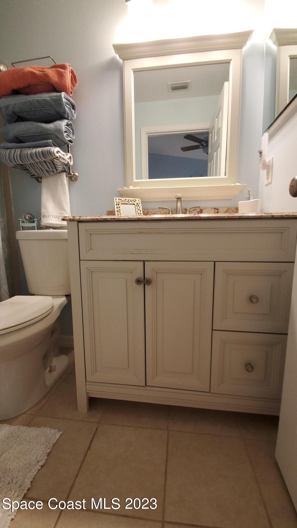 7667 North Wickham Road, Unit 916 Melbourne, FL 32940 - Photo 30 of 53 a bathroom with a granite countertop sink mirror and toilet
